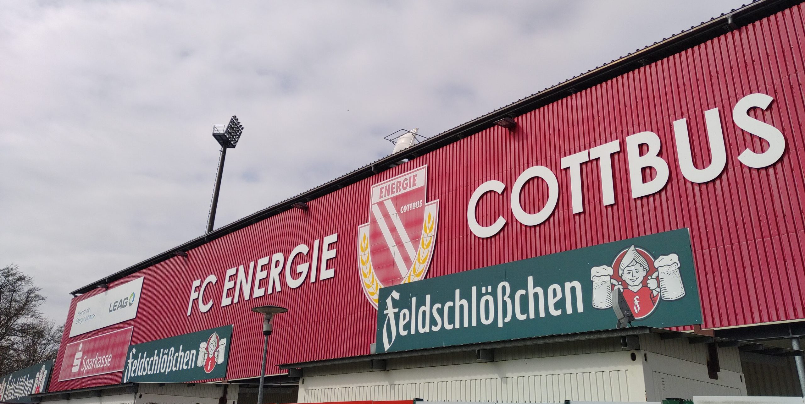 Blick auf eine Stadionwand, darauf steht "FC Energie Cottbus" und darunter Werbung für "feldschlößchen"
