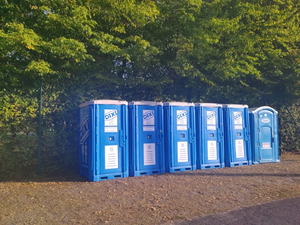 Mehrere blau-weiße Dixi-Toiletten